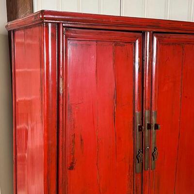 CHINESE LACQUERED CABINET | Red lacquered cabinet, with double doors opening to reveal two drawers between open shelves, with brass...