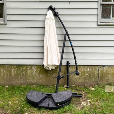 CANTILEVER LIGHTED UMBRELLA | With a solar panel attachment powering interior LED string lights, on a formed plastic base; approx. h. 8...