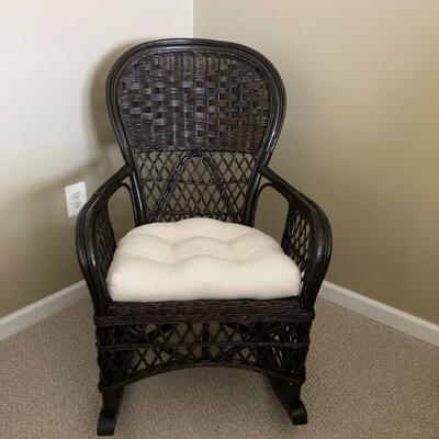 Wicker rocker with upholstered cushion.