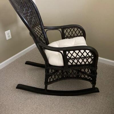 Wicker rocker with upholstered cushion.