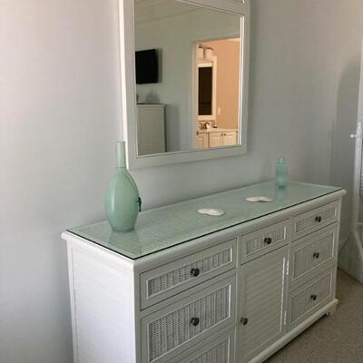 Wicker dresser with 7 drawers and one door.  Matching mirror.  Glass top. Dresser measures 63
