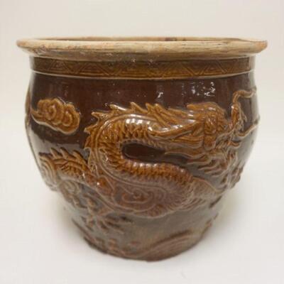 1274	ASIAN TERRACOTTA JARDINIERE W/ BROWN GLAZE & EMBOSSED DRAGON APP. 15 IN X 12 3/4 IN H. HAS A CHIP ON THE RIM
