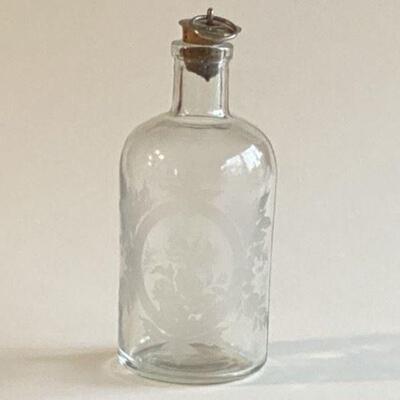 Etched bottle with cork metal lid Floral etched vase on all sides
Cork top with metal and ring
Circa 1910 