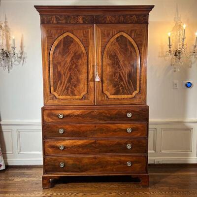 ANTIQUE LINEN PRESS | Possibly American, mahogany and walnut, having double cabinet doors with veneer arched panels, opening to reveal...