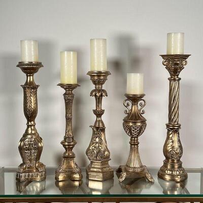 (5pc) GILT CANDLESTANDS | Gilt carved candle holders, with battery operated faux candles; tallest h. 22-3/4 in. (excluding candle),...