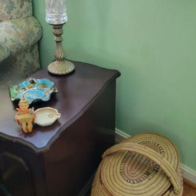 End table with lamp and hummel, covered floor basket