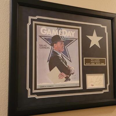 This framed tribute to the great Dallas Cowboys Coach Tom Landry includes a game day program cover from 1983, a plaque commemorating his...