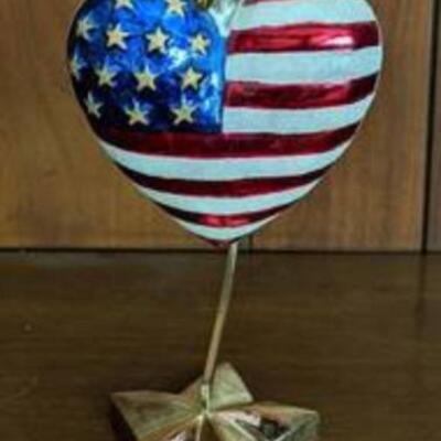 Christopher Radko American Flag Heart Ornament. Includes the stand. Measures 4.5” x 4.5”.