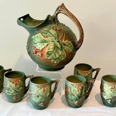 Antique Roseville Pottery Bushberry Pitcher and Six Handled Cups. The pitcher has a small chip in the base