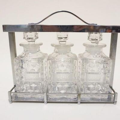 1133	3 BOTTLE ETCHED DECANTOR SET IN CHROME HOLDER, SCOTCH, RYE, BRANDY, APPROXIMATELY 11 IN X 4 IN X 10 IN HIGH
