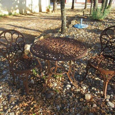 WROUGHT IRON TABLE WITH STAR AND 2 CHAIRS VERY THICK AND HEAVY. TABLE MEASURES 29" X 25"