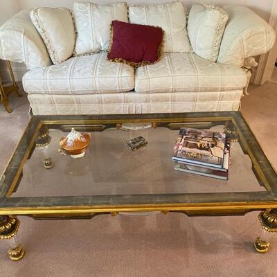 Antique glass coffee table with green and gold accents, and glass legs