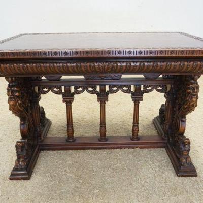 1126	HEAVILY CARVED WALNUT LIBRARY TABLE WITH CARVINGS OF LIONS, GROTESQUE FIGURES AND WOMAN ON SIDE. TOP IS PARKAY INLAY AND CARVED...