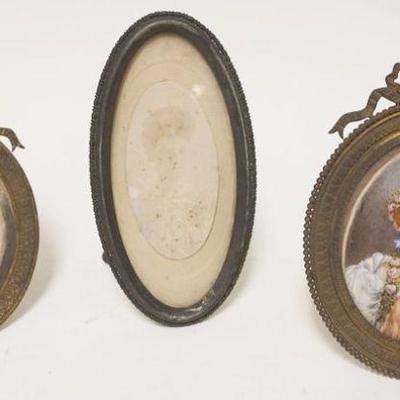 1102	LOT OF 3 ANTIQUE DRESSER FRAMES, 2 ARE BRASS. APPROXIMATELY 7 IN HIGH, 1 WITH PAINTED PORTRAIT OF WOMAN SIGNED
