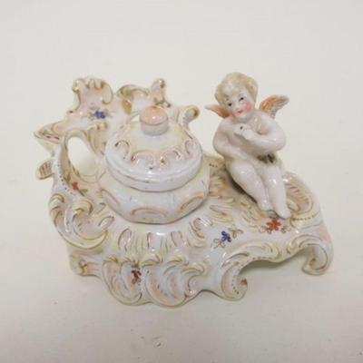 1061	ANTIQUE PORCELAIN FIGURAL INKWELL W/WINGED CHERUB, APPROXIMATELY 6 IN WIDE X 3 IN HIGH
