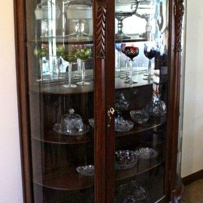 Spectacular, large triple bow front china cabinet with carved wood faces and paw feet, and wood shelves.