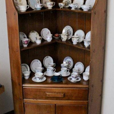 Small corner cupboard with open shelves, drawer, and lower cabinet.