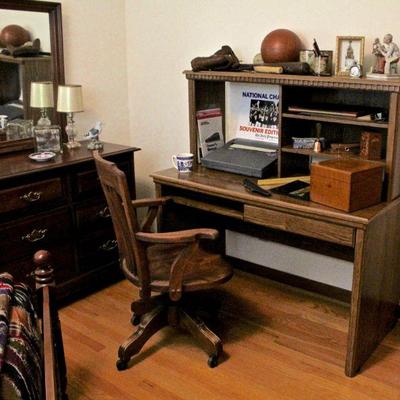 Vintage wood rolling office chair, desk, typewriter, desk accessories, sports memorabilia.
