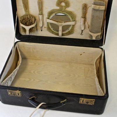 Small, vintage travel case with grooming accessories.