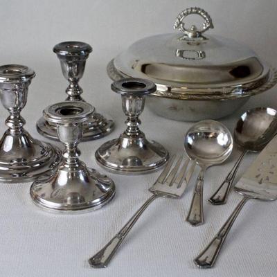 One pair of sterling candle holders, one pair of plated candle holders, silver plated serving utensils and serving bowl.
