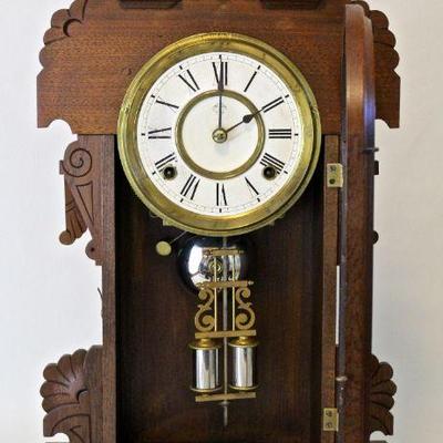 Clock door open to reveal pendulum.