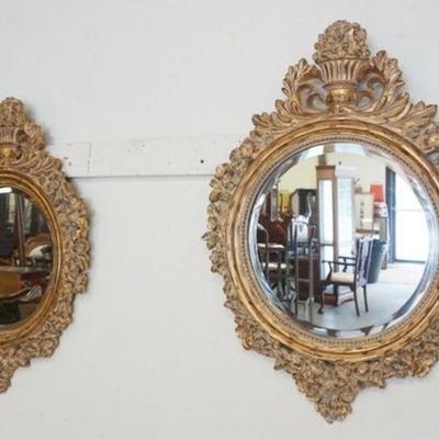 1043	PAIR OF ORNATE BEVELED EDGE ROUND MIRRORS IN GILT COMPOSITE FRAMES W/URNS AT CREST, APPROXIMATELY 24 IN X 32 IN
