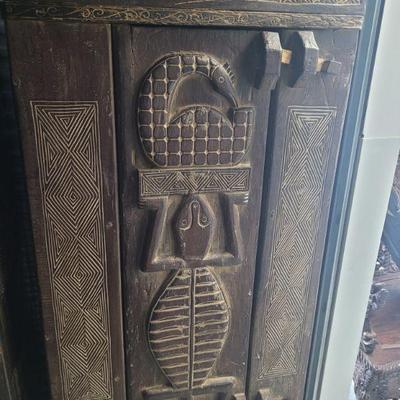 African cabinet, Lizard motif with geometric elements, approximately 5 feet 6 inches tall, it has two interior shelves, in good to very...