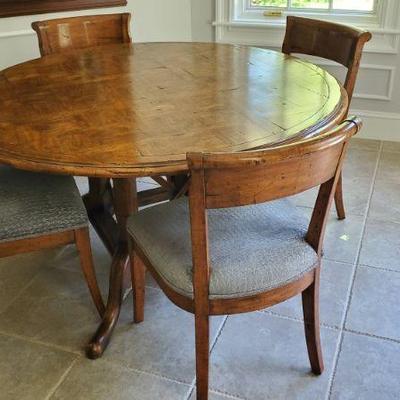Round walnut kitchen table with six chairs, four shown