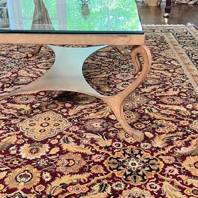 GLASS COFFEE TABLE | Low table with a glass top and a brass toned metal frame with shaped x-stretcher; h. 19 x 50 x 34 in.