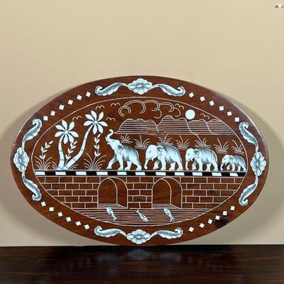 INLAID BONE ELEPHANT PLAQUE | Oval wood plaque with inlaid engraved bone depicting elephants crossing a bridge - 11-3/4 x 17-1/2 in.