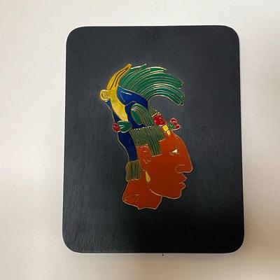 ENAMELED MAYAN HEAD | Colorful enameled Mayan figure mounted on a black painted board, with label on verso - 10-1/4 x 8 in. (overall)