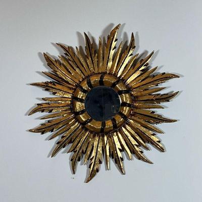 GILT SUNBURST WALL MIRROR | Central round mirror centered by feather form gilt painted carved wood sunburst motif - 16 x 15 in.