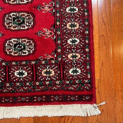 BOKHARA MAT | With five central medallions within a flower border, on a red ground - 3 ft. 2 in. x 2 ft. 2 in.