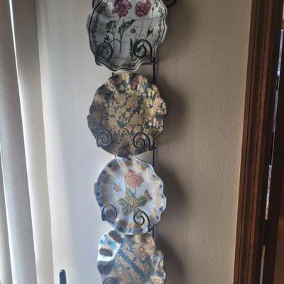 four decorative plates and a metal wall mount holder, all sold separately