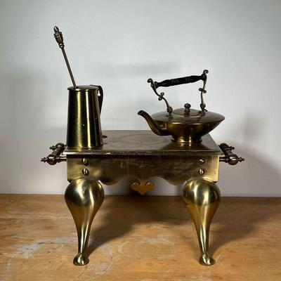(4pc) MISC. BRASS  |
Including a tall pitcher with stirrer, a teapot, and a large trivet - l. 22 x w. 16 x h. 11-1/2 in. (trivet)