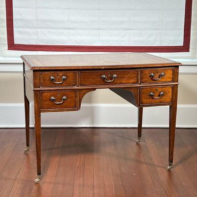 LEATHER TOP WRITING DESK  | Having an inset leather top tooled with gilding, having five drawers on straight tapering legs resting on...