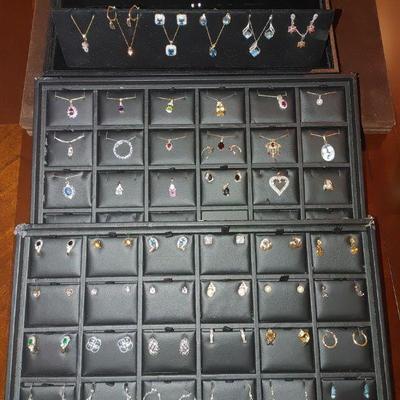 Multiple trays of gold earrings, chains, and pendants