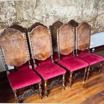 Set of 8 Leather seat fronts with armorial crest, tapestry backs, nail head trim and heavily carved wood details.  17.5W x 18.5D x 46H...