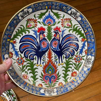 (2pc) GREEK PLATES  |  Greek sculpted pottery plates with hand coloring and gilt highlights, one showing a peacock, the other showing two...
