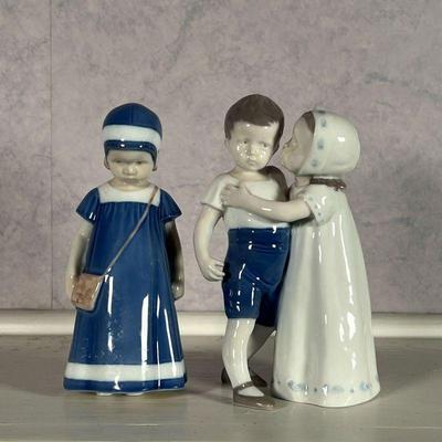 (2pc) DANISH FIGURES  |  Danish porcelain figures, including one of a girl in a blue dress, the other of a girl hugging a young boy, each...