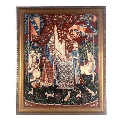 NEEDLEPOINT EMBROIDERED SCENE  |  Showing two figures with a unicorn and lion among smaller animals, with 1983 dedication on verso - w....