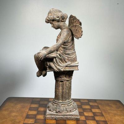 SEATED ANGEL SCULPTURE  |  Showing a fairy or angel reading on a pedestal, heavy, possibly cement - w. 9 x h. 20 in.