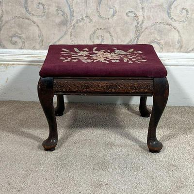 NEEDLEPOINT FOOTSTOOL  |  Small foot rest with a floral needlepoint top, the wood frame with floral carvings on small cabriole legs - l....
