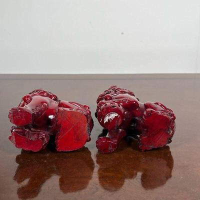 PAIR FOO DOG FIGURES  |  Foo dogs or foo lions, dark red, possibly resin or lacquered wood - l. 4 x h. 4.5 in.