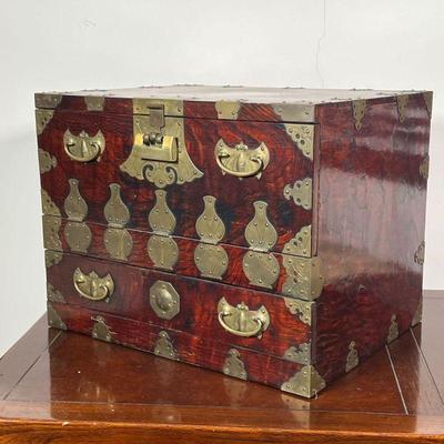CHINESE JEWELRY CHEST  |  Nicely figured red/dark wood with brass hardware, including bat form pull plates, having a hinged lid over a...