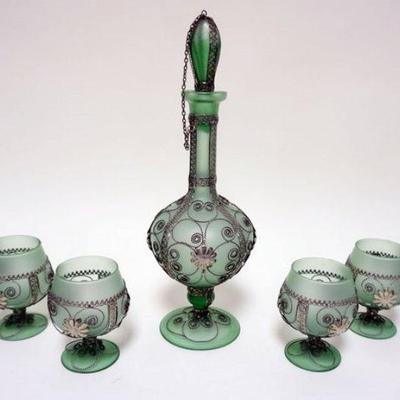 1093	GREEN SATIN GLASS DECANTOR W/6 FOOTED GLASSES ALL HAVING INTRICATE SCROLLED WIRE APPLIED, TALLEST IS APPROXIMATELY 14 IN HIGH
