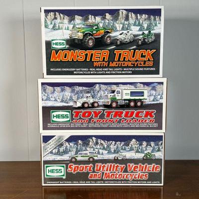 (3pc) HESS TRUCKS  |  
Including a Monster Truck with Motorcycles, Toy Truck and Front Loader, and a Sport Utility Vehicle and...