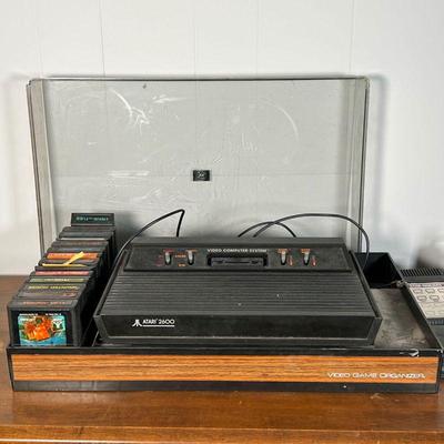 ATARI GAMING CONSOLE  |  
Atari 2600 Video Computer System in a lidded case with various games, including Asteroids, Frogger, Star...