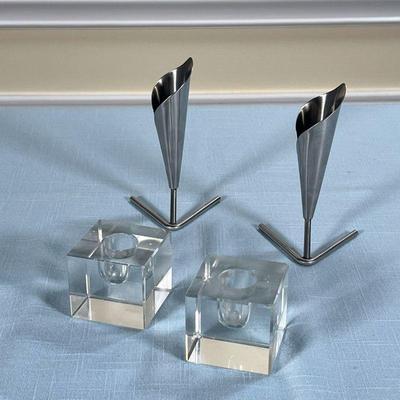 (4pc) MODERN TABLE ITEMS  |
Including a pair of Danish bud vases (h. 4 3/4 in.), and a pair of glass candlestick holders (l. 2 x w. 2 x...