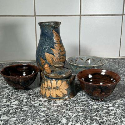 (5pc) POTTERY ITEMS  |
Including a lidded jar and a pitcher both signed with initials on the bottom, a pair of Japanese style brown...